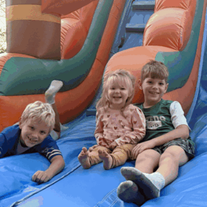 3 Kids Having Fun on a Water Slide, rented by Twin City Inflatables | Lexington, NC